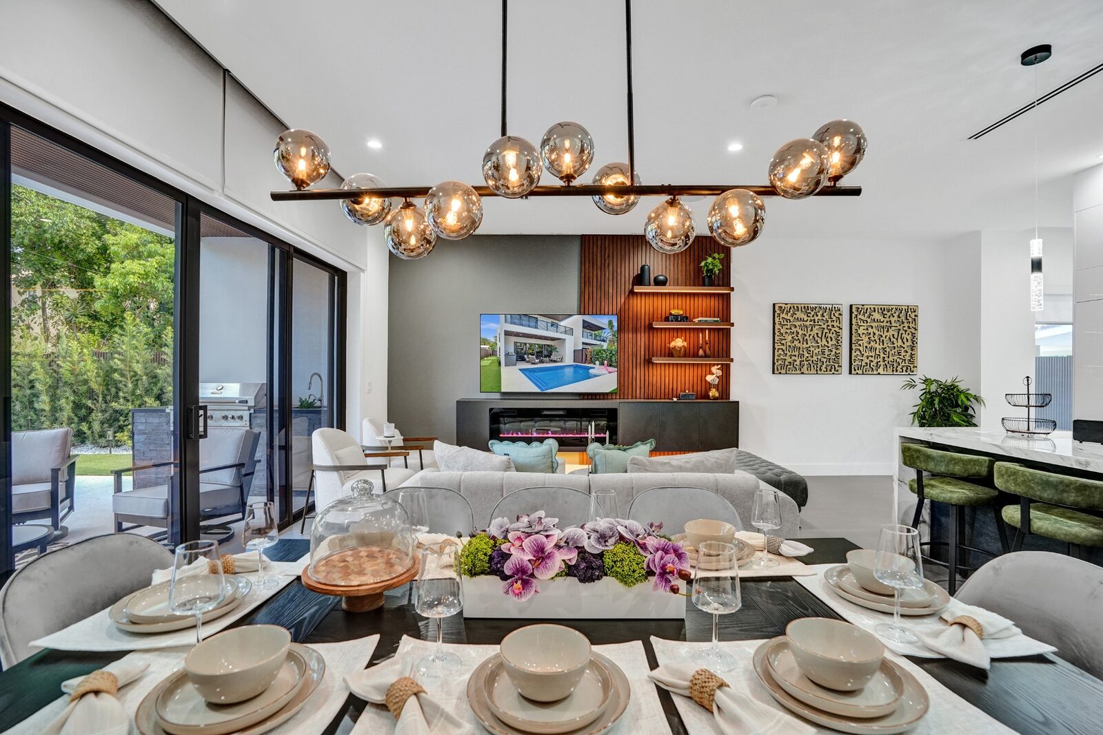 Open-concept dining and living area with statement chandelier